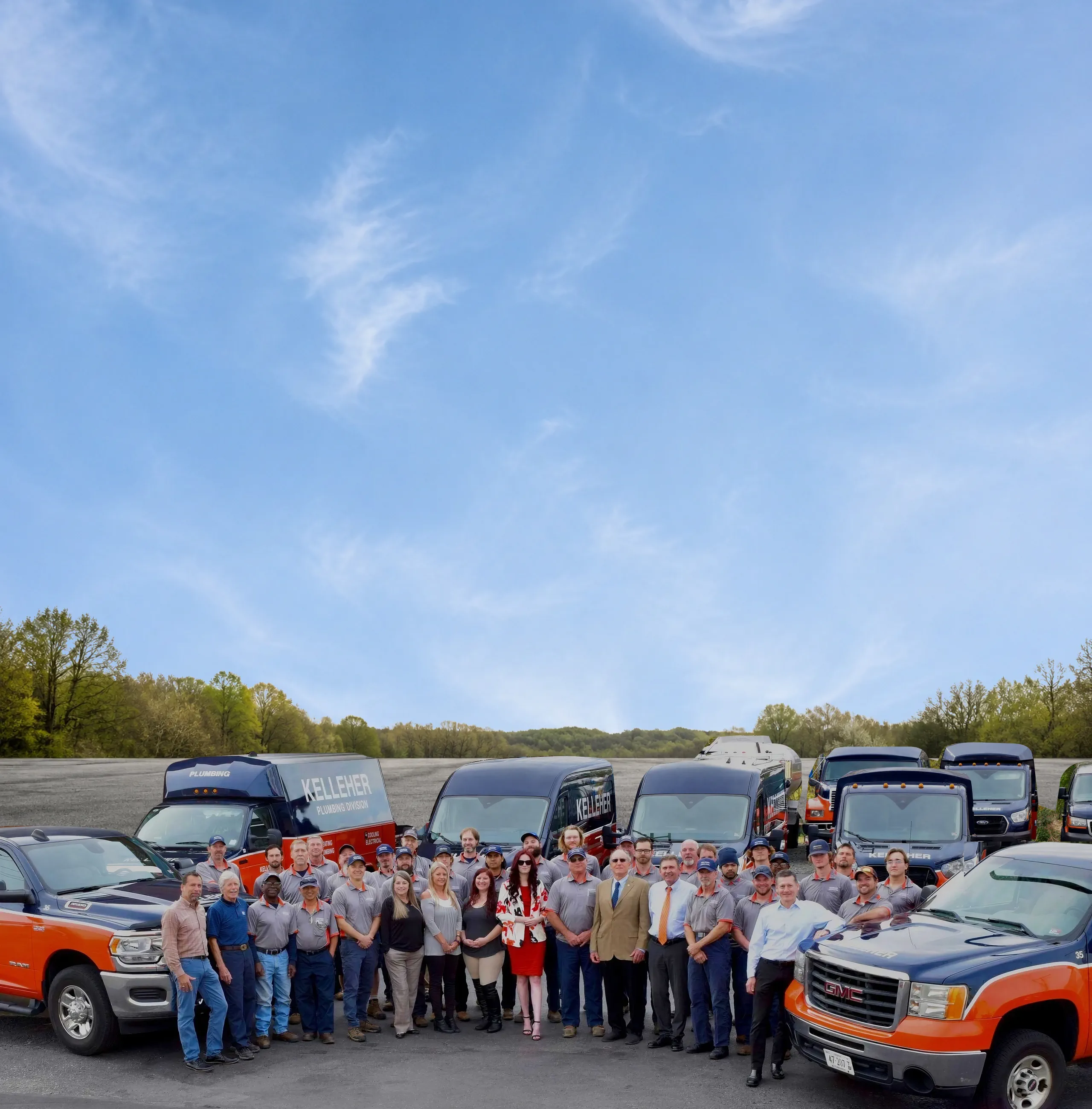 The Kelleher team together with their orange and blue company fleet